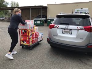 WestSide Baby staff delivering diapers to the car of our provider partner in mask and gloves